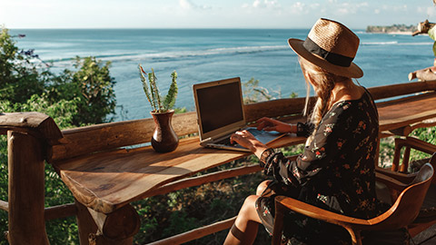 An entrepreneur working on a laptop in a picturesque location