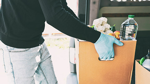 A close view of a person putting a charity donation in the back of a vehicle