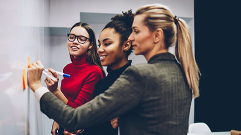 A group of copywriters working on ideas on a board