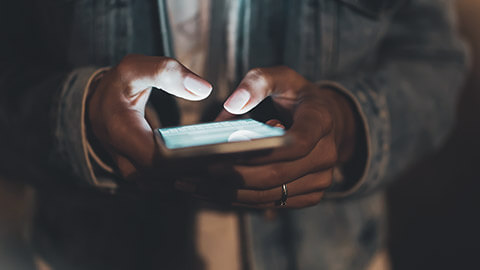 A close view of a person browing news feeds on their mobile phone