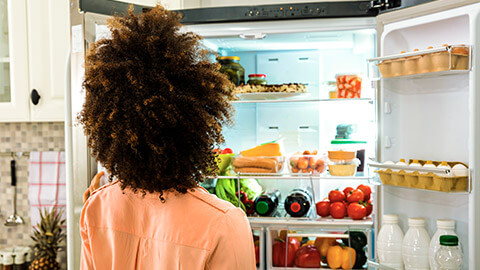 A person looking through their refrigerator for the perfect garnish