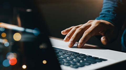 A close view of a person typing on a laptop