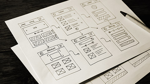 A page of wireframe diagrams on a table