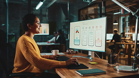 A UX designer working on a project on a desktop computer