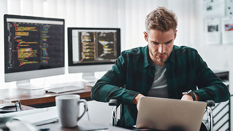 A programmer sitting at a desk working intently on a problem