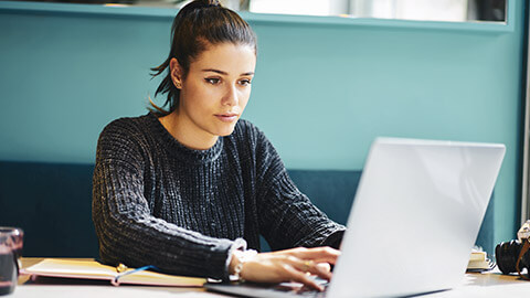 A designer using project management software on a laptop