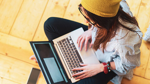 A top down view of a designer working on a project on a laptop