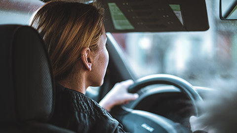 Over the shoulder image of a person in a car in traffic