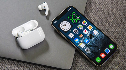 An Apple iPhone sitting on a desk with other apple products