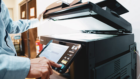 An employee using a laser printer in an office