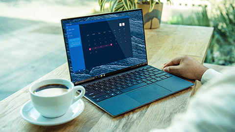 A person using a DELL laptop on a desk