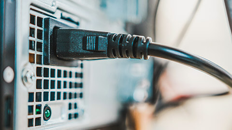 A close view of a power cord in the back of a computer