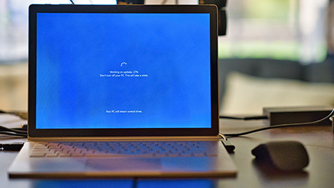 A Windows laptop sitting on a desk running a system update