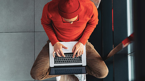 Top down view of a programmer working on a laptop