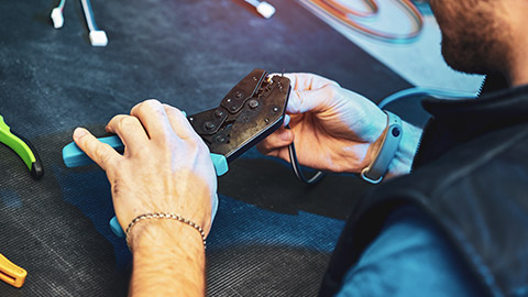 A person using a wire crimping tool