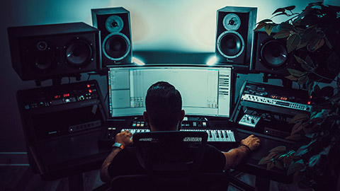 Over-the-shoulder view of a sound engineer sitting at a desk