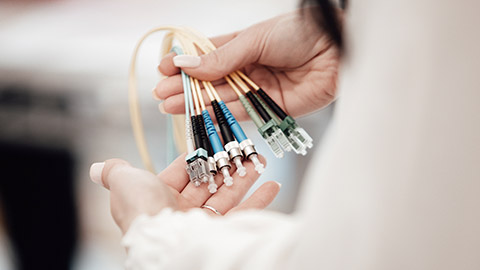 A person holding some fibre optic cables