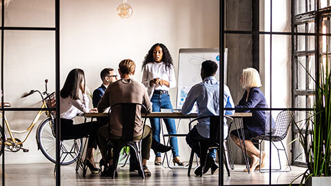 A young professional taking their team through an upcoming initiative in a modern office