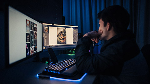 A designer using multiple screens and programs