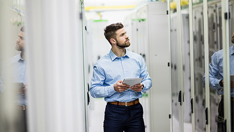 Technician using digital tablet in server room