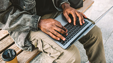 A developer seated in a public place, working remotely on a small, open-source project