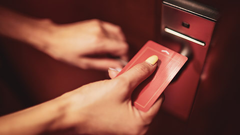 A close view of a person opening a hotel room with a swipe key