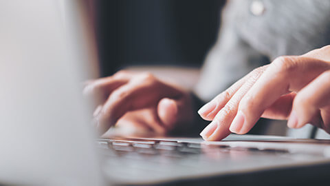 A close view of a person typing on a laptop