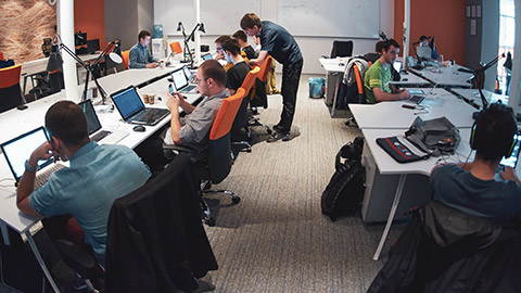 A wide shot of a group of programmers in an office space