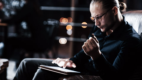 A person looking intently at their tablet