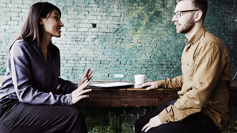 Two people looking happily at a laptop