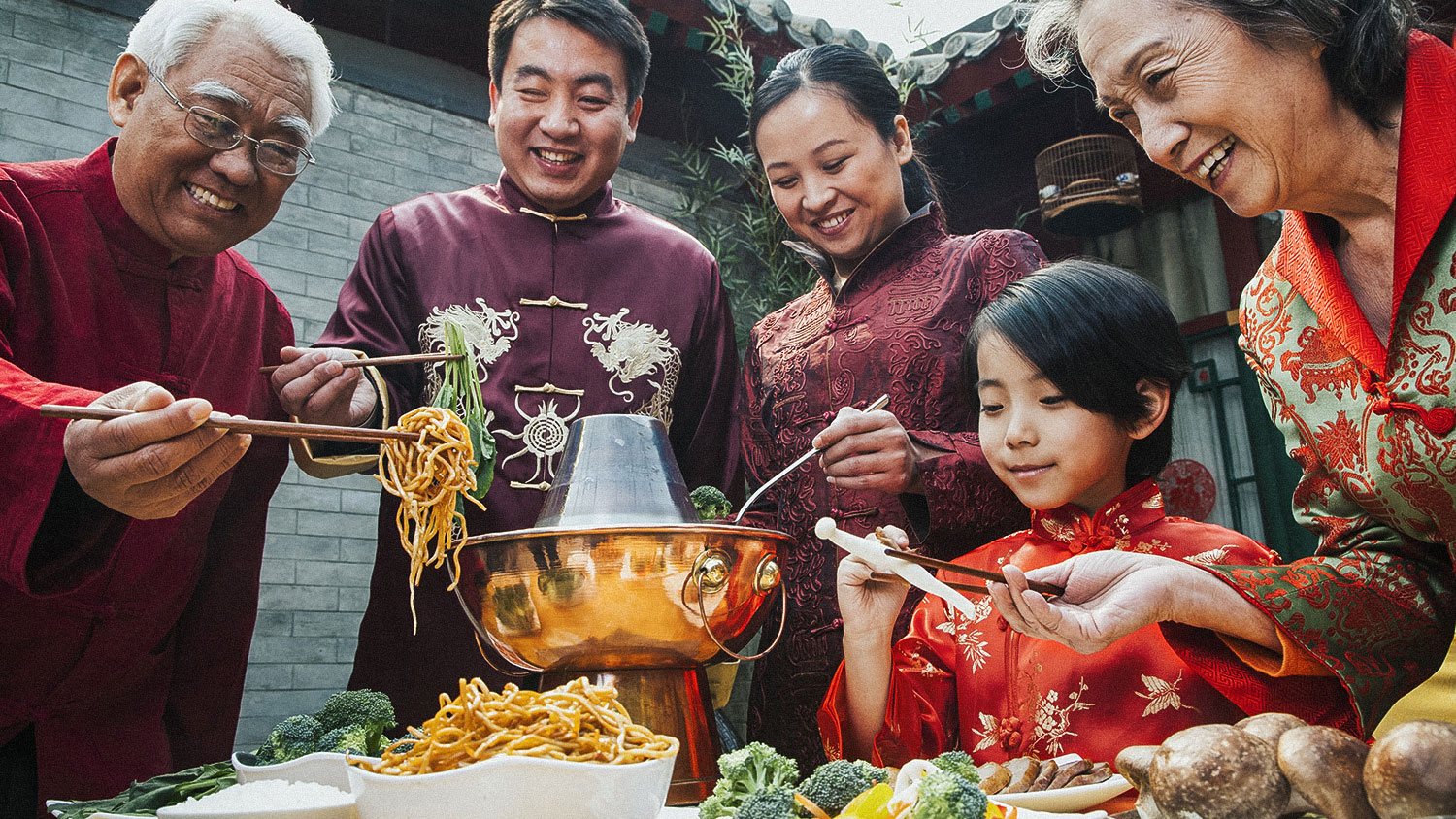 Family enjoying Chinese meal in traditional Chinese clothing