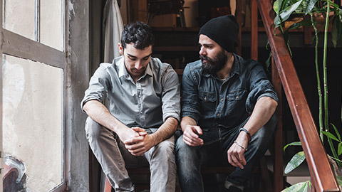 Males sitting on steps talking