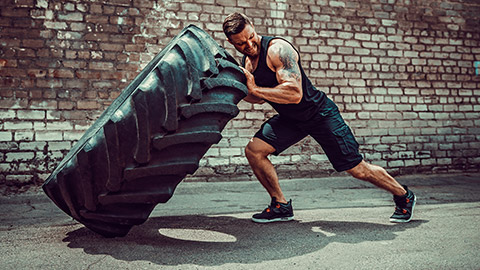 Male doing crossfit tractor tyre exercise