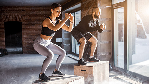 Couple performing squat exercise