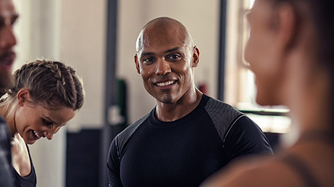 Group of sweaty people talking in a gym after working out