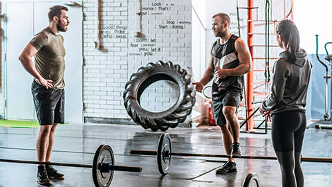 Trainer explaining exercise to 2 clients