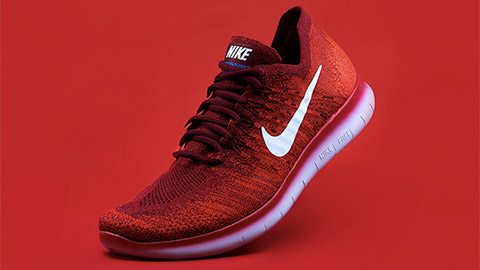 Red Nike Free Run shoe isolated on red background