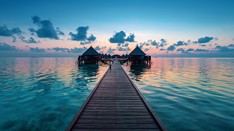 over water bungalow on pacific island at sunset