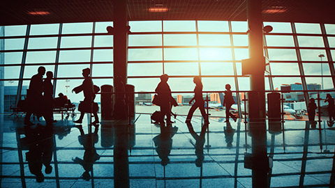 silhouettes of people walking through an airport