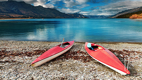 two kayaks on the shore of a lake