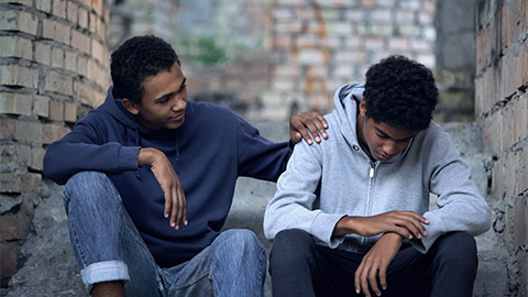 An upset young person being supported by a friend