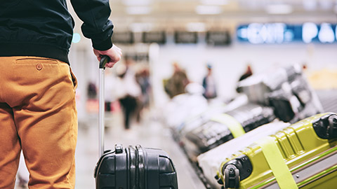 man standing at airport baggage carousel