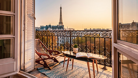 hotel room with doors open and eiffel tower in the distance