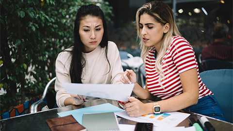 Two business owners analysing a range of financial reports