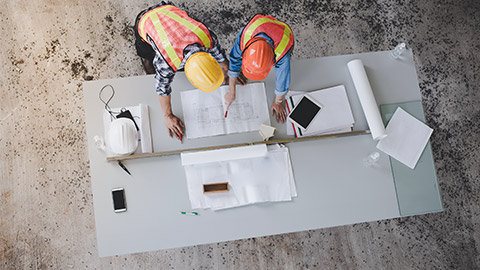 Two workers overlooking measurements and making calculations.