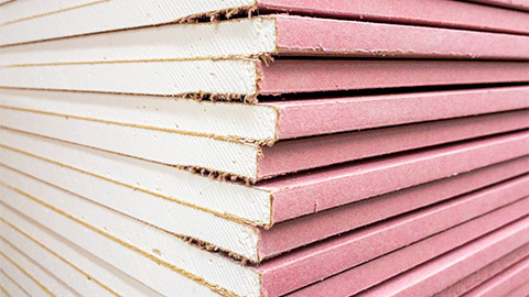 A close-up of a stack of plasterboard