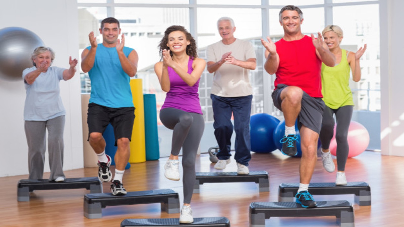 A mixed age adult group fitness step aerobics class