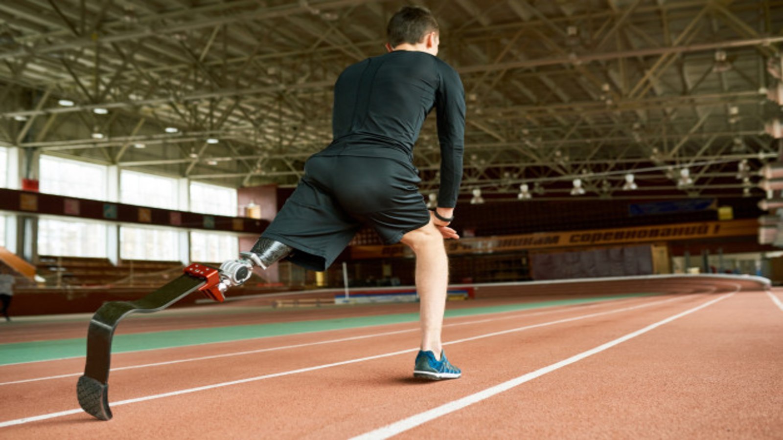 A handicapped runner at the starting line, wearing a blade on his left leg.