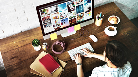 Female designer sitting at her desk using a desktop computer