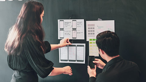 Two designers working on design wireframes